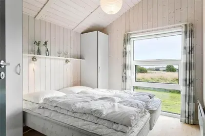 a bedroom with a large bed with a window at 858-Thisted-Delfinvej-24 in Thisted