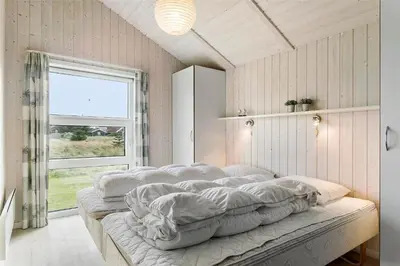 a room with four beds in it with a window at 858-Thisted-Delfinvej-24 in Thisted