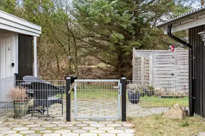 a gate to a yard with a bench and a fence at 118-Vestervig-Sivsangervej-18 in Vestervig