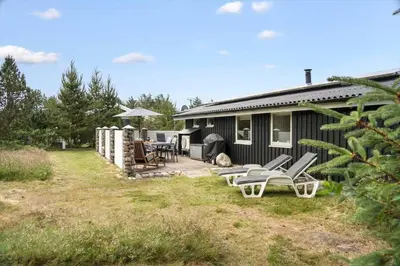 a house with a patio with chairs and a grill at 118-Vestervig-Sivsangervej-18 in Vestervig