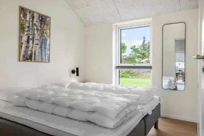 a white bedroom with a large bed and a window at 1300-Thisted-Smedevej-3-B in Thisted