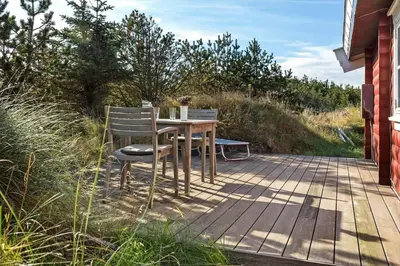 a wooden table and chair sitting on a deck at 651-Snedsted-Somaerkevej-50 in Snedsted