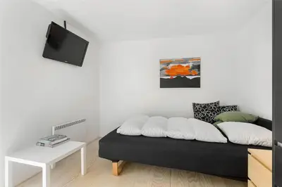 a living room with a black couch and a tv at 768-Snedsted-Somaerkevej-68 in Snedsted