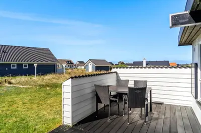 a wooden deck with a table and chairs on it at 586-Thisted-Havbovej-30 in Thisted