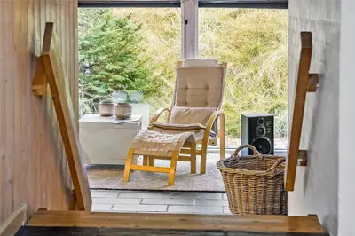 a rocking chair sitting on a porch next to a window at 1030-Thisted-Lyngstien-15-A in Torsted