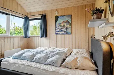 a bed in a room with wooden walls and windows at 512-Thisted-Sotungevej-4 in Thisted