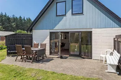 a patio with a table and chairs in front of a house at 142-Thisted-Pighvarvej-4 in Thisted