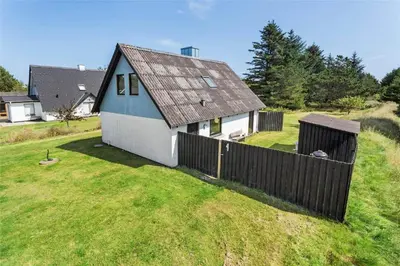 a small house with a fence in a yard at 142-Thisted-Pighvarvej-4 in Thisted
