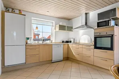 a kitchen with wooden cabinets and a white refrigerator at 133-Thisted-Jorgen-Hedes-Vej-10 in Thisted