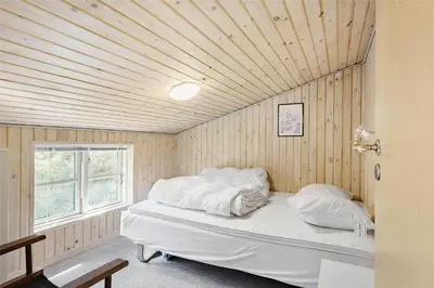 a bed in a room with a wooden ceiling at 710-Thisted-Klitrosevej-10 in Thisted