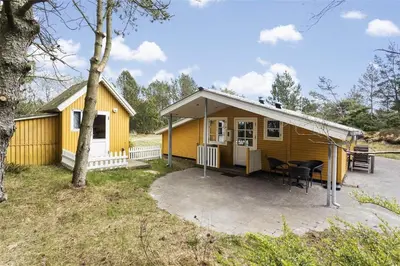 a small yellow house with a table and chairs at 710-Thisted-Klitrosevej-10 in Thisted