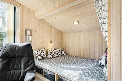 a bedroom with a bed in a room with wooden walls at 710-Thisted-Klitrosevej-10 in Thisted