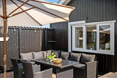 a table and chairs with an umbrella on a patio at 145-Thisted-Fiskervej-25-B in Thisted