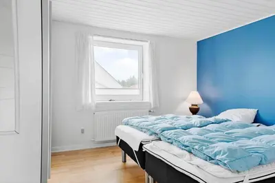 a blue bedroom with a bed and a window at 822-Thisted-Bredkaervej-8 in Thisted