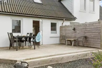 a wooden deck with a table and chairs on it at 822-Thisted-Bredkaervej-8 in Thisted