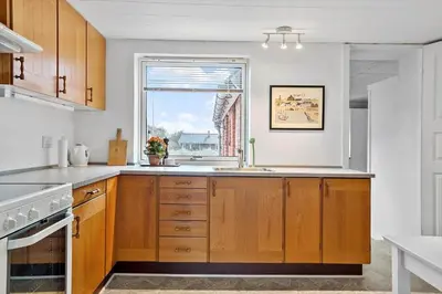 a kitchen with wooden cabinets and a window and a sink at 172-Thisted-Fiskervej-72 in Thisted