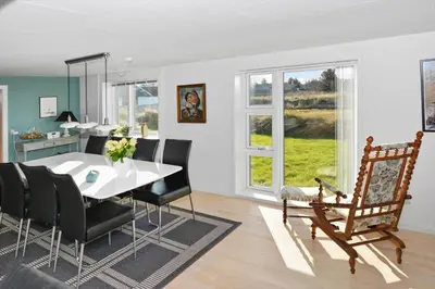 a dining room with a white table and black chairs at 172-Thisted-Fiskervej-72 in Thisted