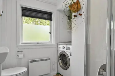 a bathroom with a washing machine and a window at 576-Thisted-Klemsvej-26-E in Thisted