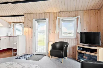 a living room with a television and a chair at 276-Thisted-Nordsovej-76 in Thisted