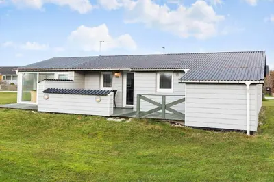 a small white house with a porch in a field at 276-Thisted-Nordsovej-76 in Thisted