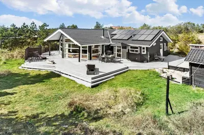 a large house with a large deck in a field at 1050-Thisted-Spanggardsvej-5 in Torsted