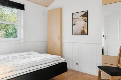 a white bedroom with a bed and a window at 1050-Thisted-Spanggardsvej-5 in Torsted