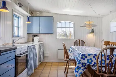 a kitchen with a table with a blue and white table cloth at 957-Thisted-Hvidbakken-33-Lille-hus in Torsted
