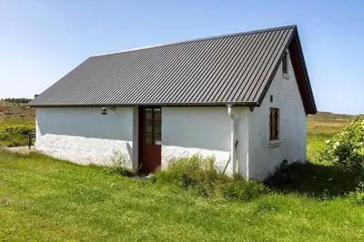a white building with a metal roof in a field at 957-Thisted-Hvidbakken-33-Lille-hus in Torsted