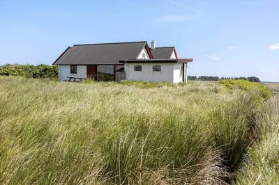 a house sitting on top of a field of tall grass at 957-Thisted-Hvidbakken-33-Lille-hus in Torsted