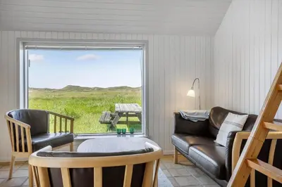 a living room with a couch and a chair and a window at 957-Thisted-Hvidbakken-33-Lille-hus in Torsted