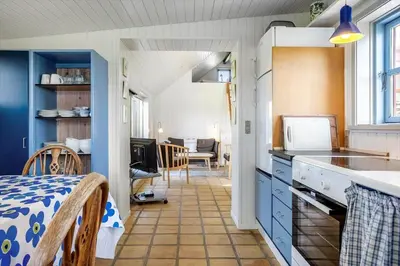 a kitchen with blue cabinets and a dining room at 957-Thisted-Hvidbakken-33-Lille-hus in Torsted
