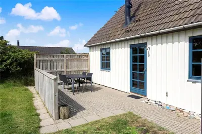 a patio with a table and chairs next to a house at 520-Snedsted-Sarasvej-10 in Snedsted