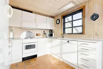 a kitchen with white cabinets and a window at 520-Snedsted-Sarasvej-10 in Snedsted