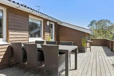 a patio with a table and chairs on a deck at 815-Thisted-Blamunkevej-45 in Thisted