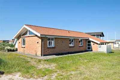 a brick house with a red roof on a field at 451-Thisted-Nordsovej-20 in Thisted