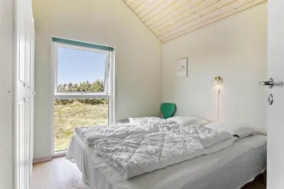 a bedroom with a large bed and a window at 969-Thisted-Klitstien-50 in Torsted