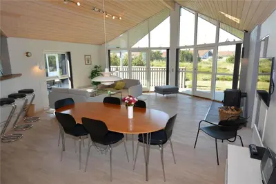 a living room with a wooden table and chairs at 969-Thisted-Klitstien-50 in Torsted