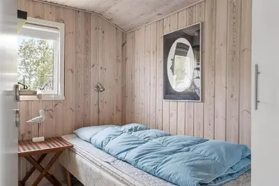 a bed in a room with a wooden wall at 770-Thisted-Nordsovej-180 in Thisted