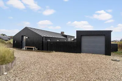 a black house with a garage and a fence at 904-Thisted-P-Bolesens-Vej-15 in Torsted