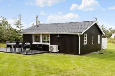 a black house with a deck and a grill at 1308-Thisted-Tunvej-12 in Thisted