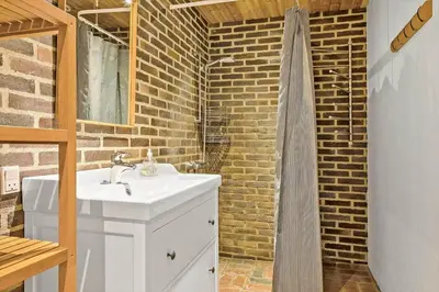 a bathroom with a sink and a brick wall at 991-Thisted-Liusborg-Sti-23 in Torsted