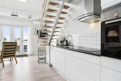 a kitchen with white cabinets and a spiral staircase at 266-Vestervig-Havnevej-1-lejl-19 in Vestervig
