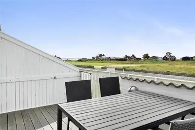 a table and chairs on a balcony with a view of a field at 266-Vestervig-Havnevej-1-lejl-19 in Vestervig