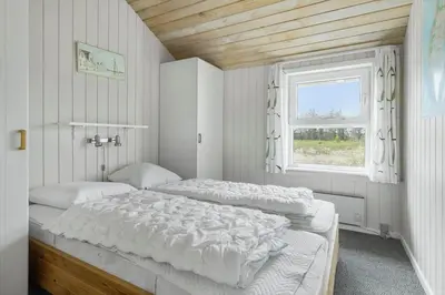 a bedroom with two beds and a window at 1052-Thisted-Bavnbak-50 in Torsted