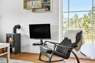 a living room with a chair and a television and a fireplace at 760-Thisted-Pighvarvej-30 in Thisted
