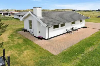 a small white house with a patio in a field at 760-Thisted-Pighvarvej-30 in Thisted