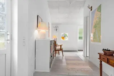 a hallway with white walls and a table with a lamp at 459-Snedsted-Istrupvej-48 in Snedsted