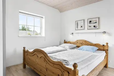 a bedroom with a wooden bed in a room with a window at 222-Thisted-Nordsovej-57 in Thisted