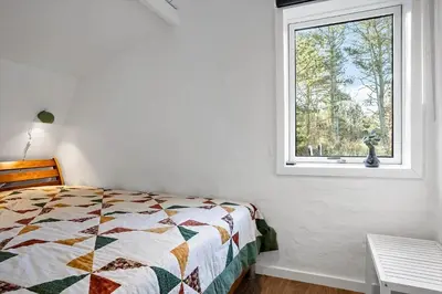 a bedroom with a bed and a window at 1315-Thisted-Sandtornvej-15 in Thisted