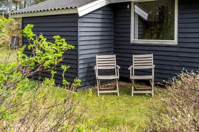 two chairs sitting on the side of a house at 1315-Thisted-Sandtornvej-15 in Thisted